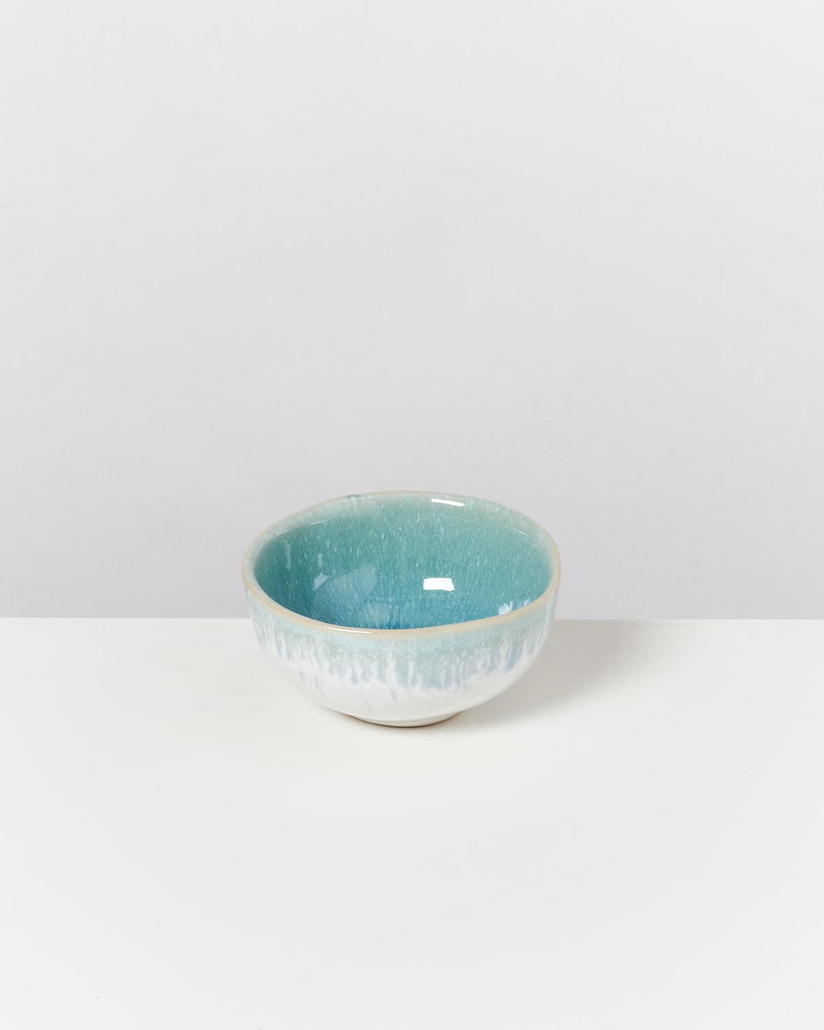 Kleine Keramikschale mit blauem und weißem Farbverlauf auf einem weißen Hintergrund.