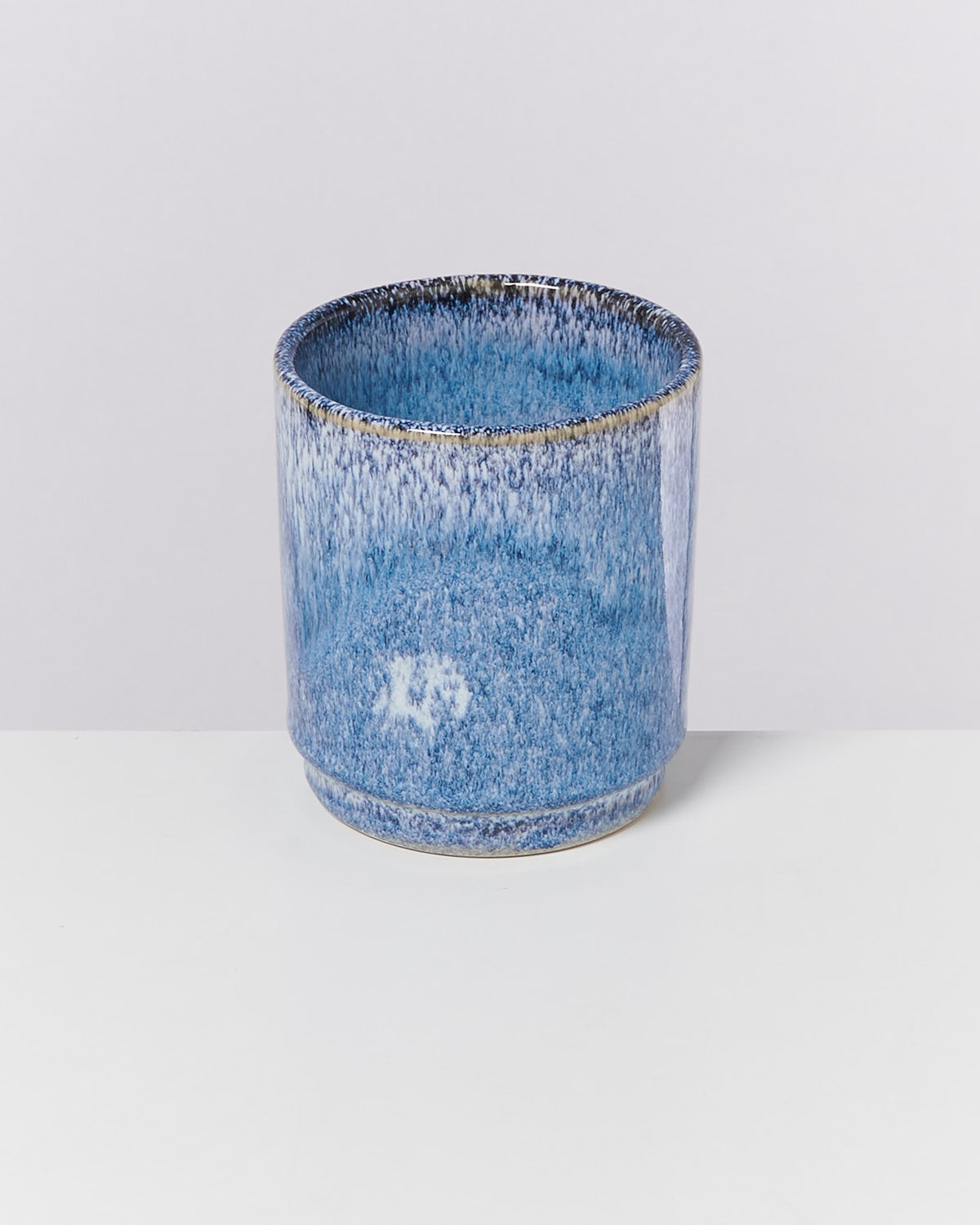 Blauer Keramiktopf mit gesprenkelter Glasur auf weißem Hintergrund.
