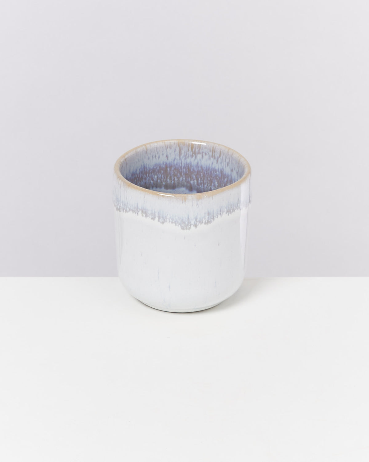 Weiße Keramikschale mit blau-grauem Rand auf einem weißen Hintergrund.