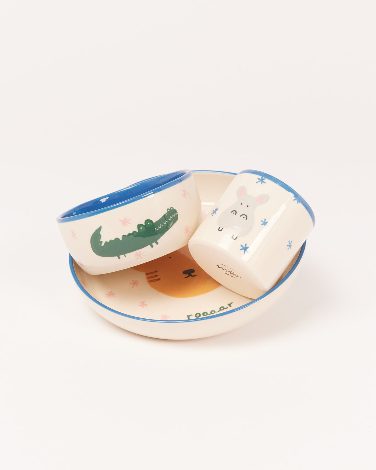 Drei bunte Kindergeschirrteile mit Tiermotiven: ein Krokodil, ein Nilpferd und ein Löwe.